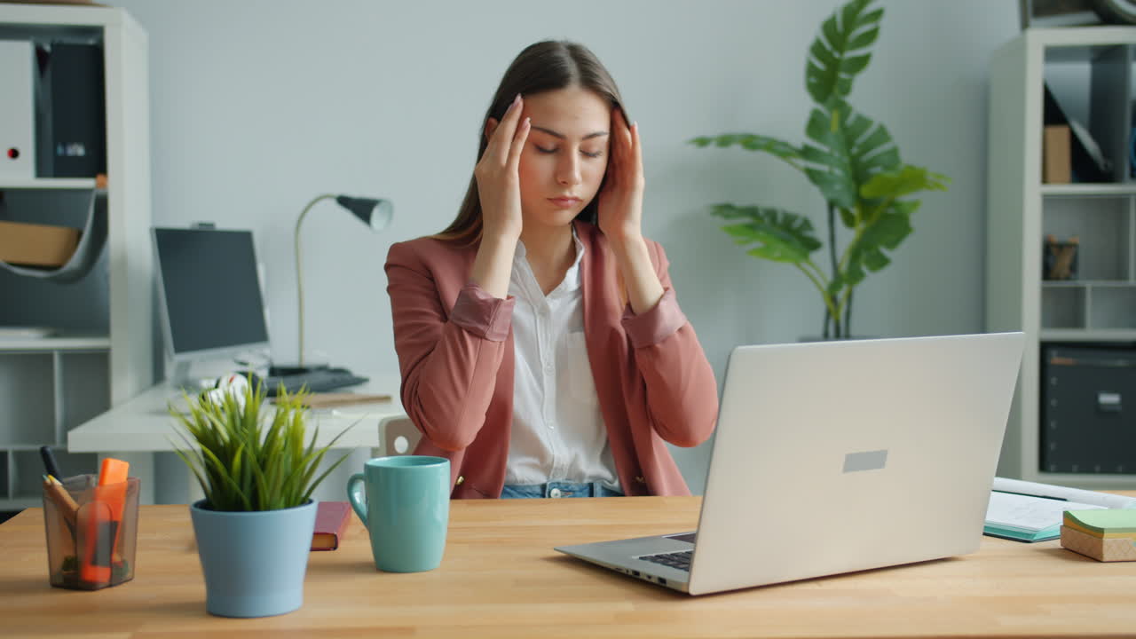 Woman Experiencing Headache at Her Desk