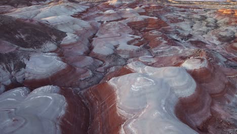 Aerial-4k-drone-view-of-Bentonite-Hills,-Utah,-at-golden-hour-with-colorful-mars-like-landscape-flyover-pan-down-shot