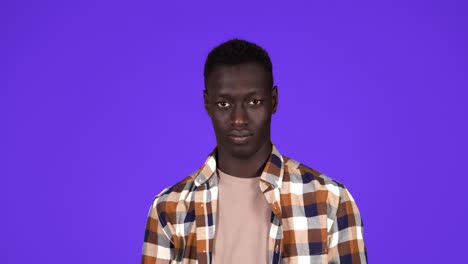 portrait of carefree afro american man stubble throwing up hands shrugging saying have no clue isolated over blue background. concept of emotions