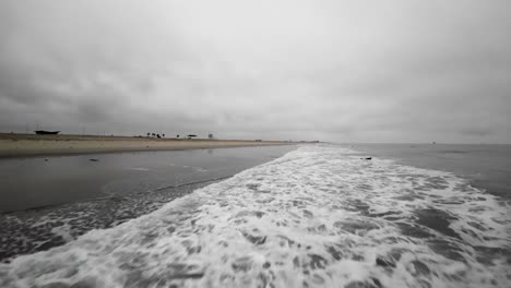 Flying-fast-and-low-over-the-waves-along-Huntington-Beach-in-Orange-County,-California