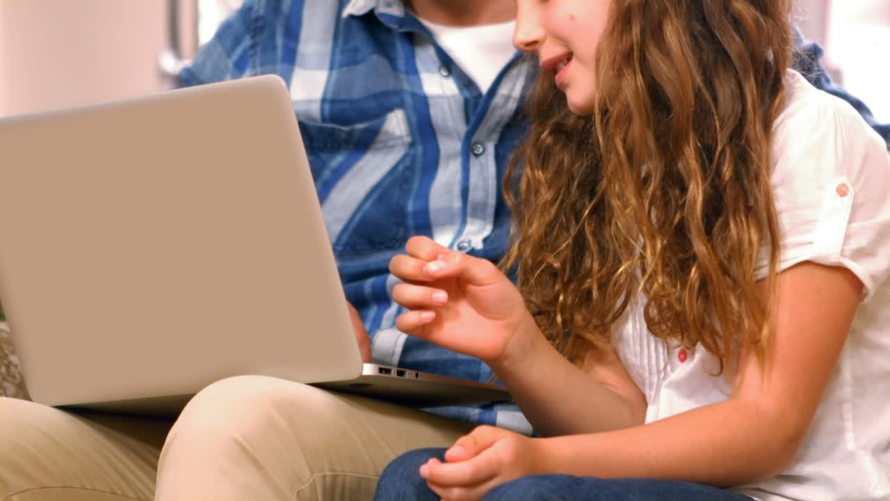 padre e hija usando una computadora portátil