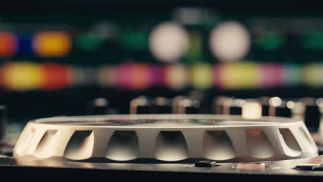 detailed shot of a dj's hand turning a knob on a mixer during a live performance, focusing on the equipment.