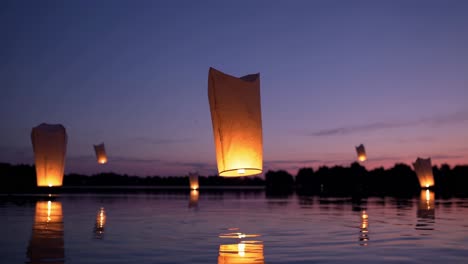 sky lanterns floating peacefully, casting warm glows across tranquil lake surface during twilight, reflecting soft illumination on water's mirror like expanse