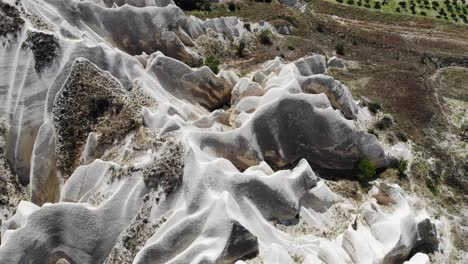 aire mavic moviéndose sobre algunas colinas blancas hacia el valle de goreme mostrando la asombrosa conformación