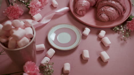 Person-drinking-cup-of-tea-on-pink-table