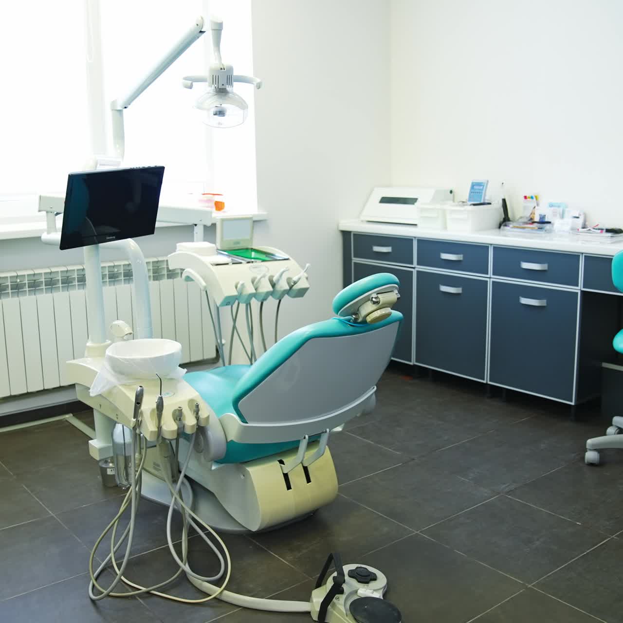 Medical office of dentistry with modern equipment and tools. Light clean room with desk and sofa for comfort of patients and doctors
