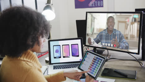 African-american-businesswoman-on-video-call-with-african-american-male-colleague-on-screen