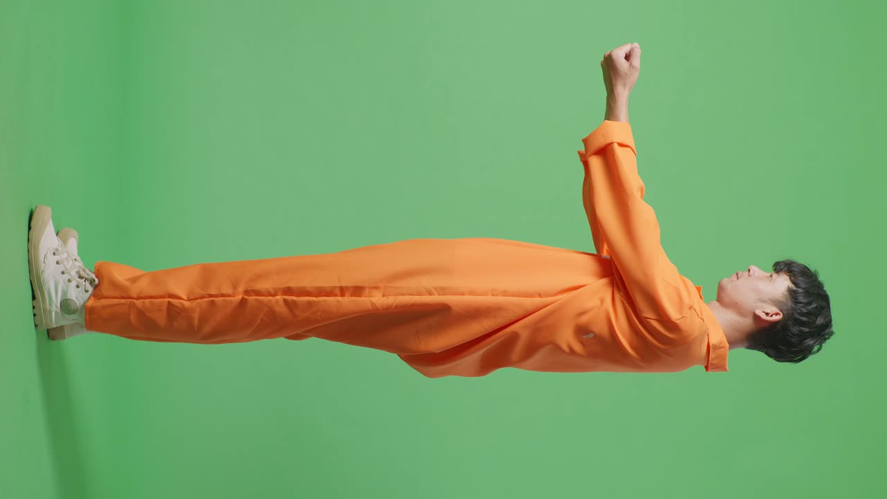 아시아 남성 수감자의 몸 전체 측면 뷰 손을 펴고 녹색 스크린 배경에 서서 자신을 항복합니다.