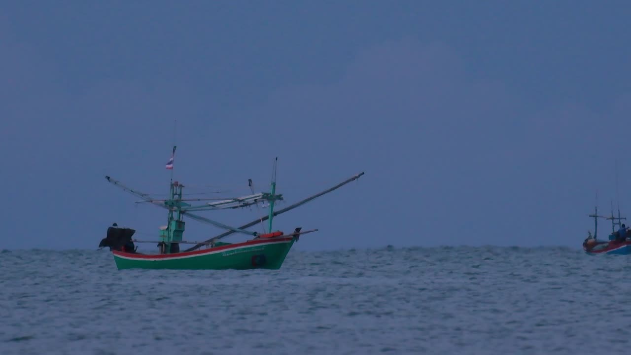 los barcos de pesca en tailandia esperan en medio del océano a que oscurezca para poder encender sus luces verdes y comenzar a pescar y pescar camarones