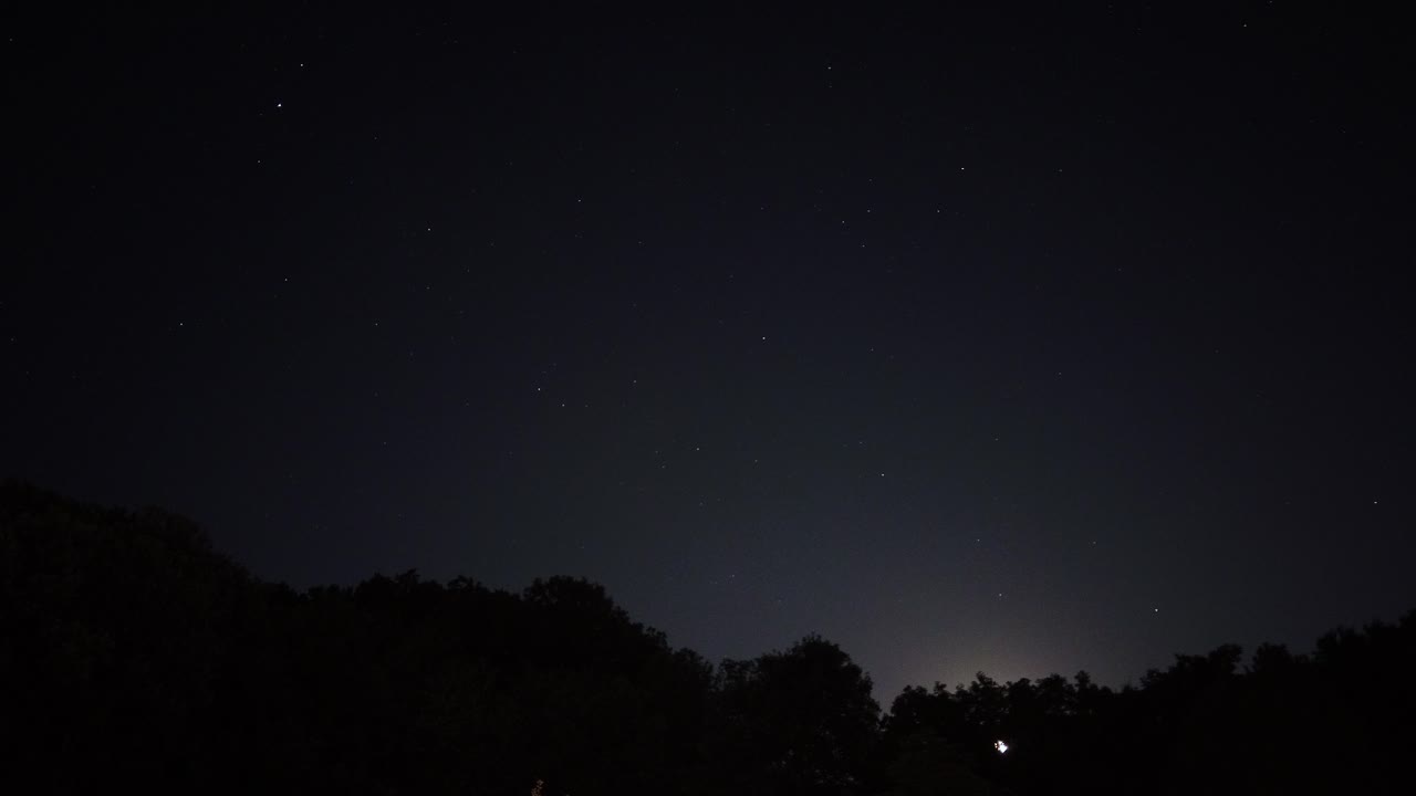 별과 달이 숲의 실루엣에 숨어 있는 밤하늘의 동작 시간 경과