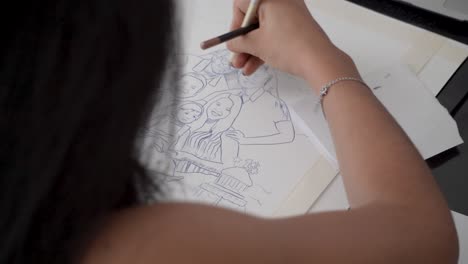 back view of black haired latina young female working on family drawing