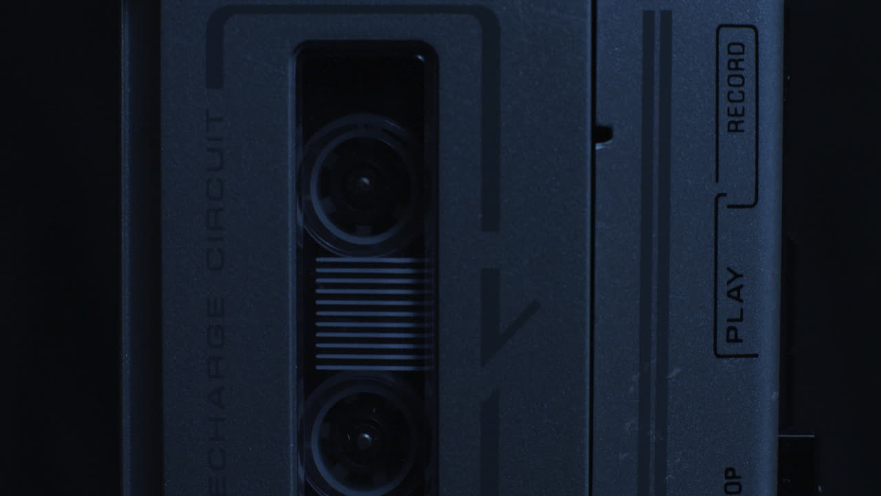 incline desde los carretes de la grabadora de microcassette en movimiento hasta la luz de grabación iluminada con luz azul fría