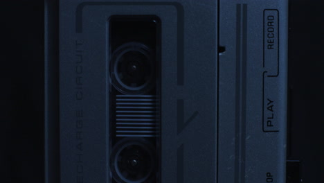 incline desde los carretes de la grabadora de microcassette en movimiento hasta la luz de grabación iluminada con luz azul fría
