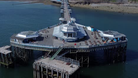 llandudno pier seaside resort landmark silver pavilion wooden boardwalk aerial view orbit left slowly