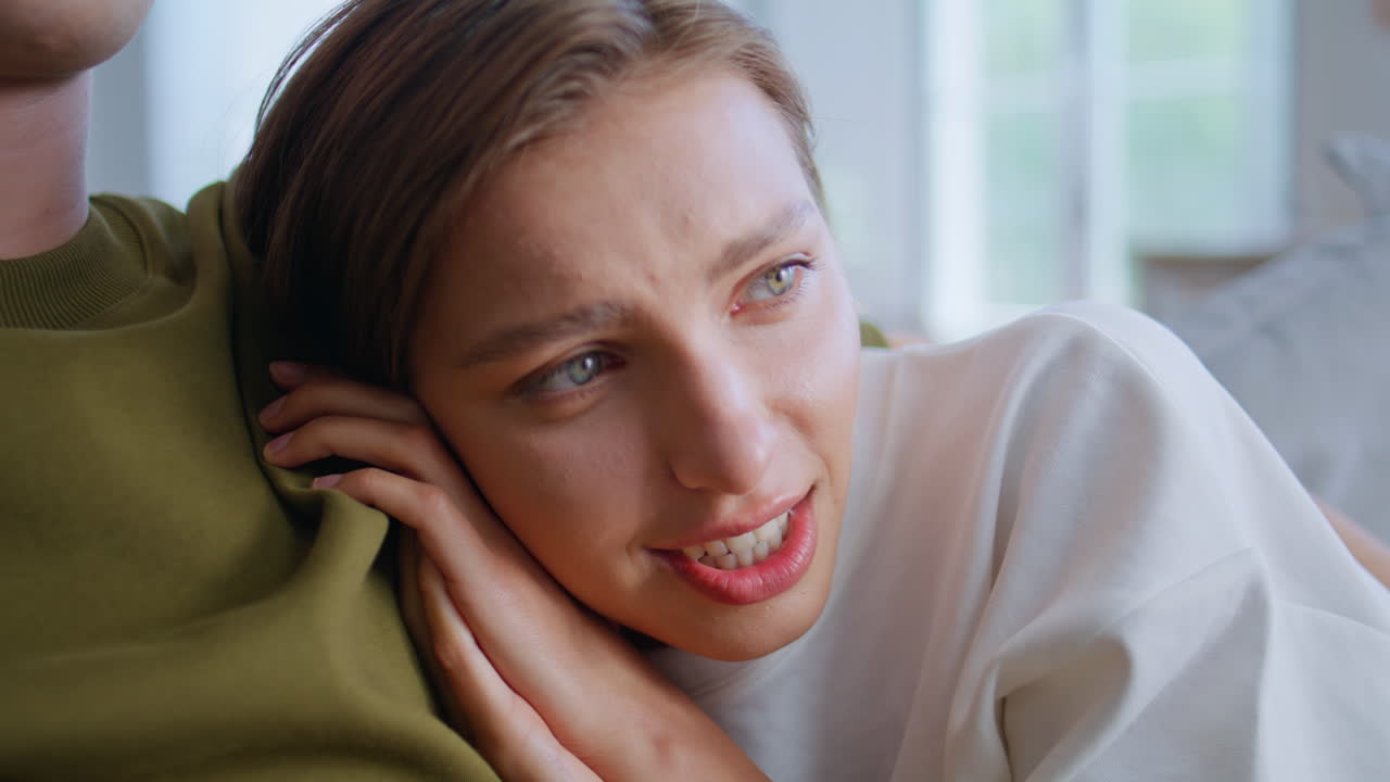 Scared girlfriend bonding boyfriend watching horror sofa closeup. Woman afraid
