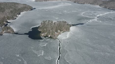 Drone-shot-of-a-big-island,-surrounded-by-frozen-water