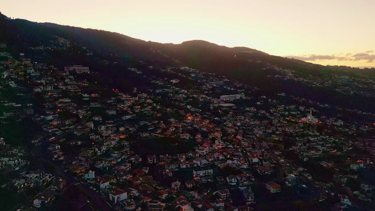 Alba luminosa che illumina le colline ricoperte dalle accoglienti vie della città. Mattina arancione