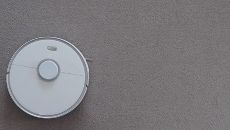 robot vacuum cleaner driving on carpet, top view