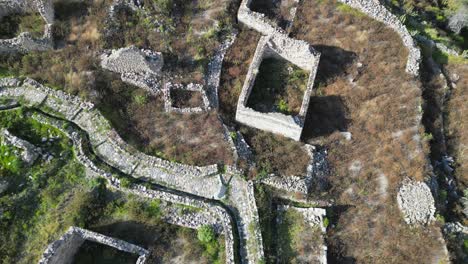 aerial looks down onto stone ruins of uyo uyo town site in south peru