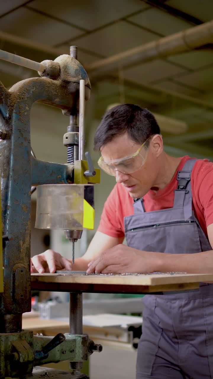 Skilled Man Operating a Drill Press in a Workshop