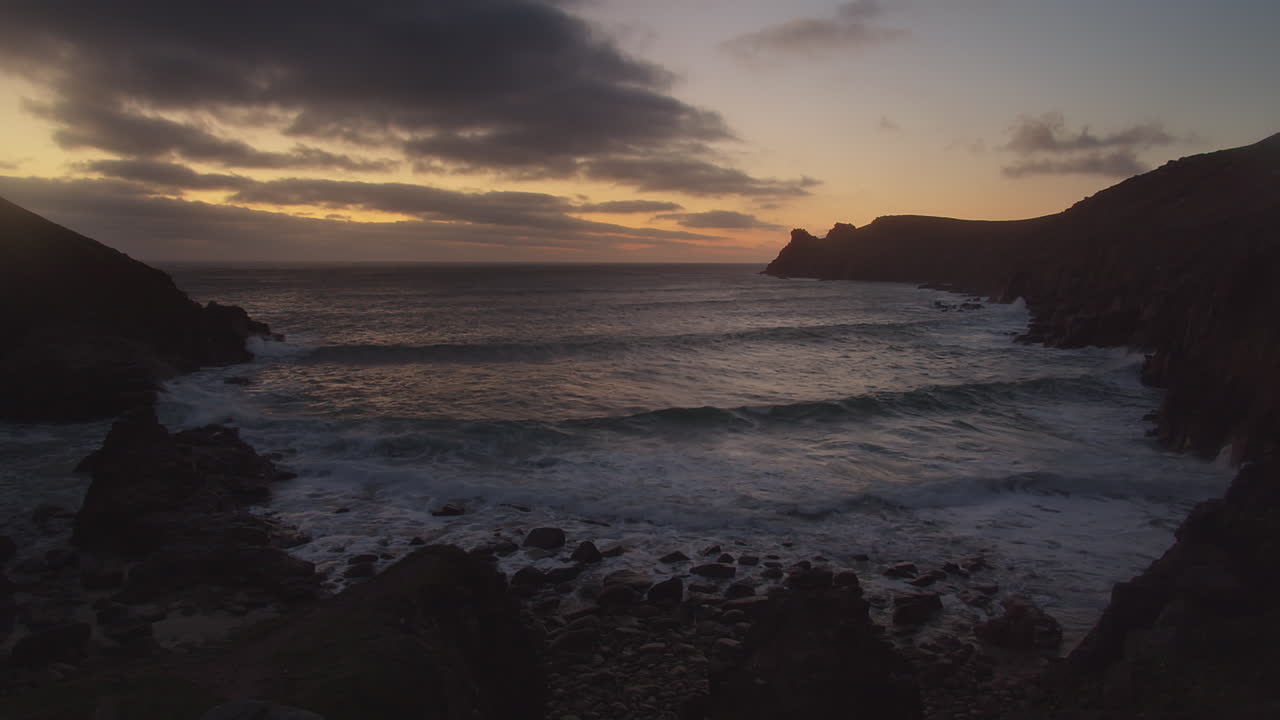 Ondas Quebrando na Costa Rochosa da Enseada e Praia de Nanjizal ao Pôr do Sol em St Levan, Cornwall, Reino Unido.