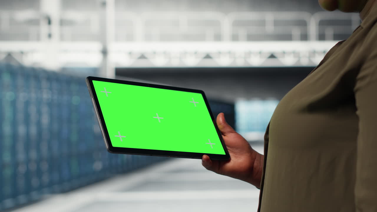 IT professional in data center using green screen tablet