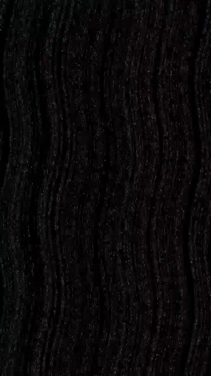 Abstraktní vlnitá černá textura s jemnými třpytivými částicemi