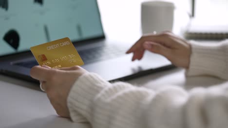 female hands holding credit card and using laptop. online shopping