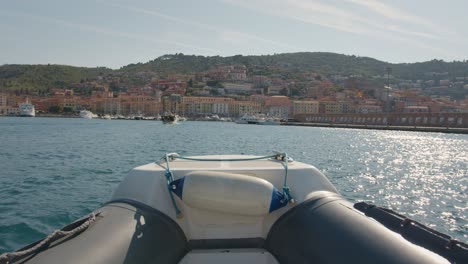 view on harbor porto santo stefano with colorful houses from a rubber boat