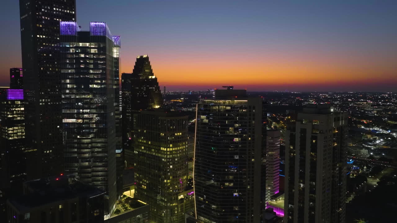 vista aérea que se eleva hacia los rascacielos iluminados, por la noche en houston, estados unidos