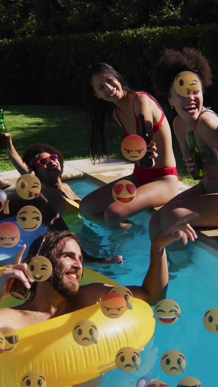 Vertical video: Group toasting by pool on float camera holding causing emoji overlay for marketing