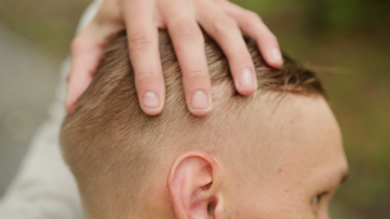 젖은 짧은 머리, 야외에 있는 백인 학생, 젖은 질감의 머리를 손으로 매만지는 모습, 클로즈업 프로필, 흐릿한 녹색 공원 배경, 흐린 날씨, 머리카락에 맺힌 빗방울, 친밀한 손질