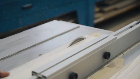 a worker saws a board on a sawing machine. sawdust from the tree is flying in different directions. slow motion images