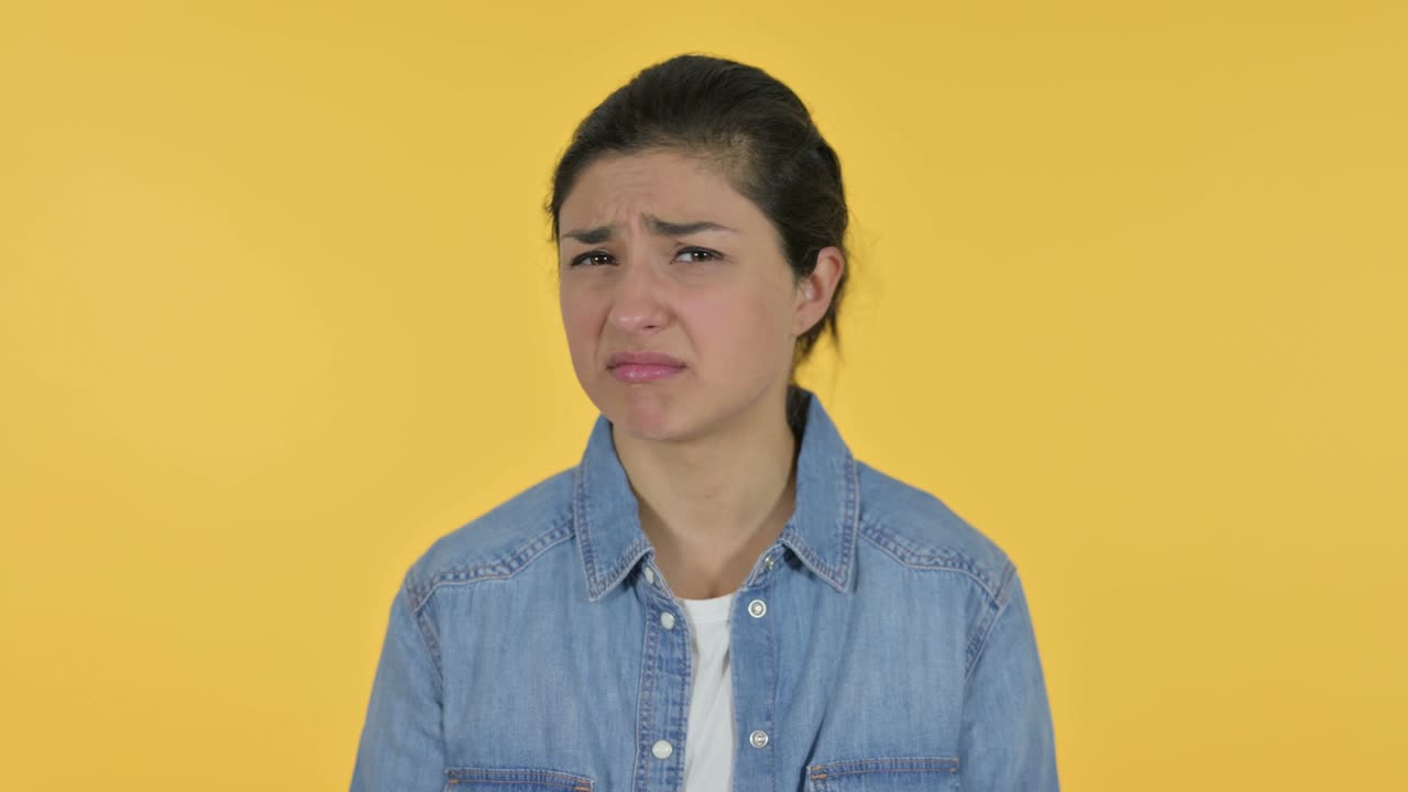 Young Indian Woman having Loss, Yellow Background