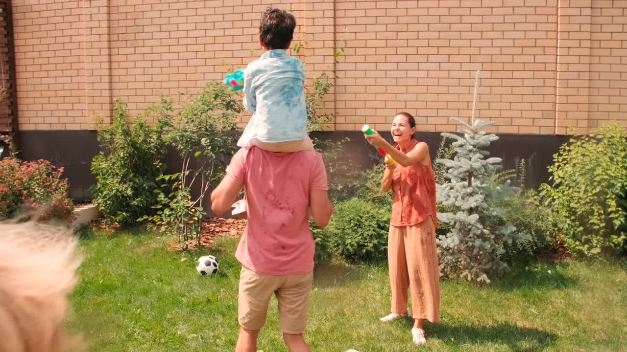 Big Family Shooting Water Guns Outdoors