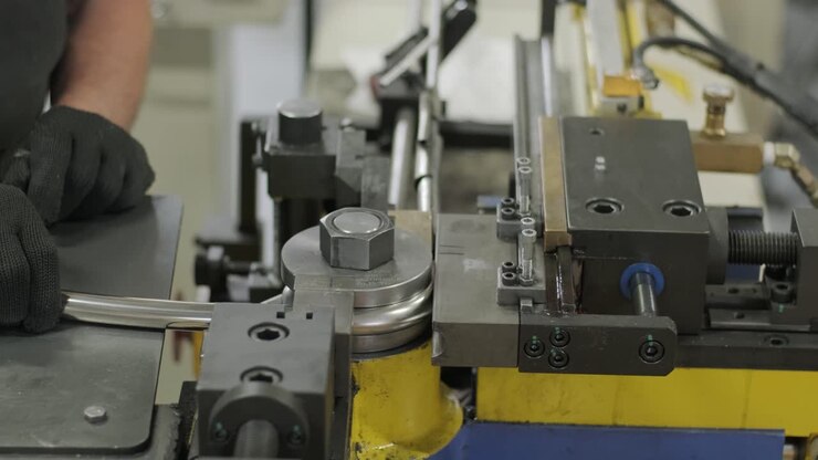 Macchina piegatrice industriale per la piegatura di tubi metallici in fabbrica. Macchina automatica per la lavorazione dei metalli per la tornitura elettronica di tubi metallici e la piegatura a freddo in un capannone industriale presso un impianto di produzione.