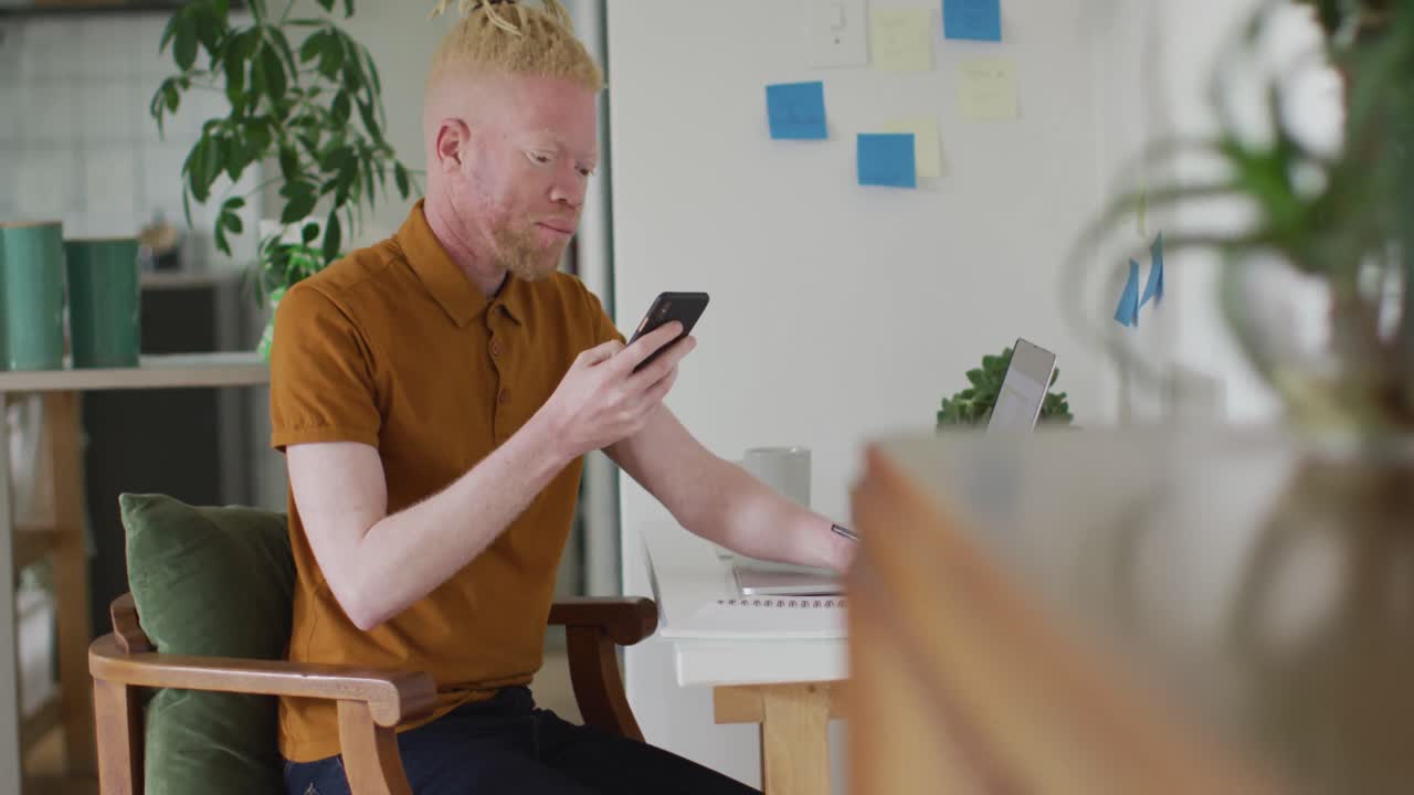 Albino african american man with dreadlocks making video call on the laptop
