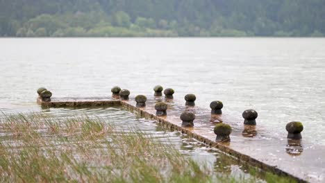 Lake-dock-view-with-calm-waves-in-Lagoa-das-Furnas-in-Azores-Islands,-Portugal