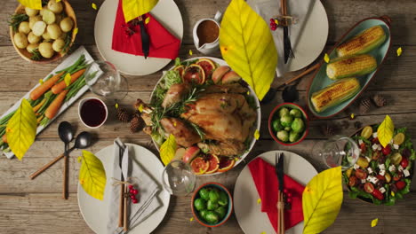 Animation-of-autumn-leaves-over-thanksgiving-dinner-background