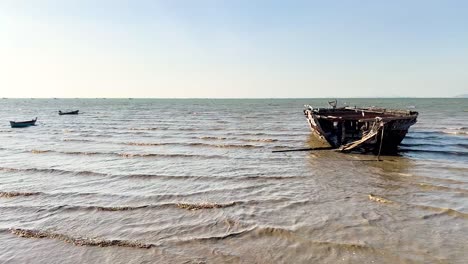 waves surround a stranded ship on pattaya beach