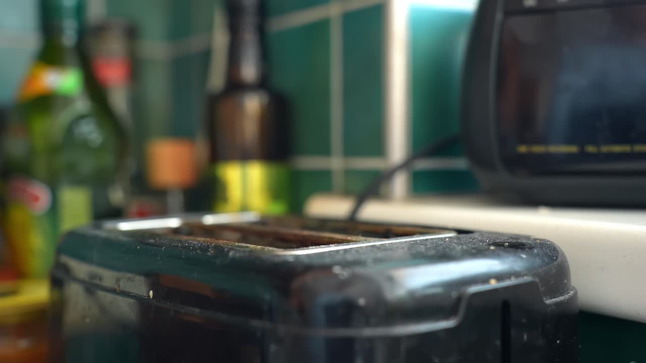 Slow motion toast pops up from a kitchen toaster, fresh bread jumping after heating. Breakfast morning routine b-roll with copy space
