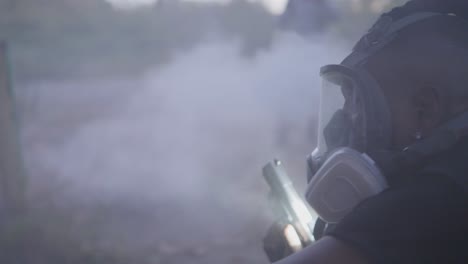 close-up of a man wearing a gas mask and tactical vest moving through a smoky environment. dark, intense urban action scene
