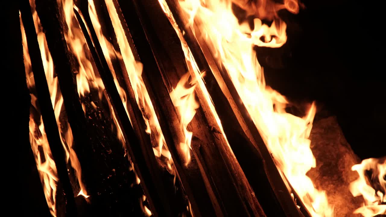 밤에는 자연의 검은색 배경에서 느린 동작으로 큰 불꽃이 불타고 있습니다.