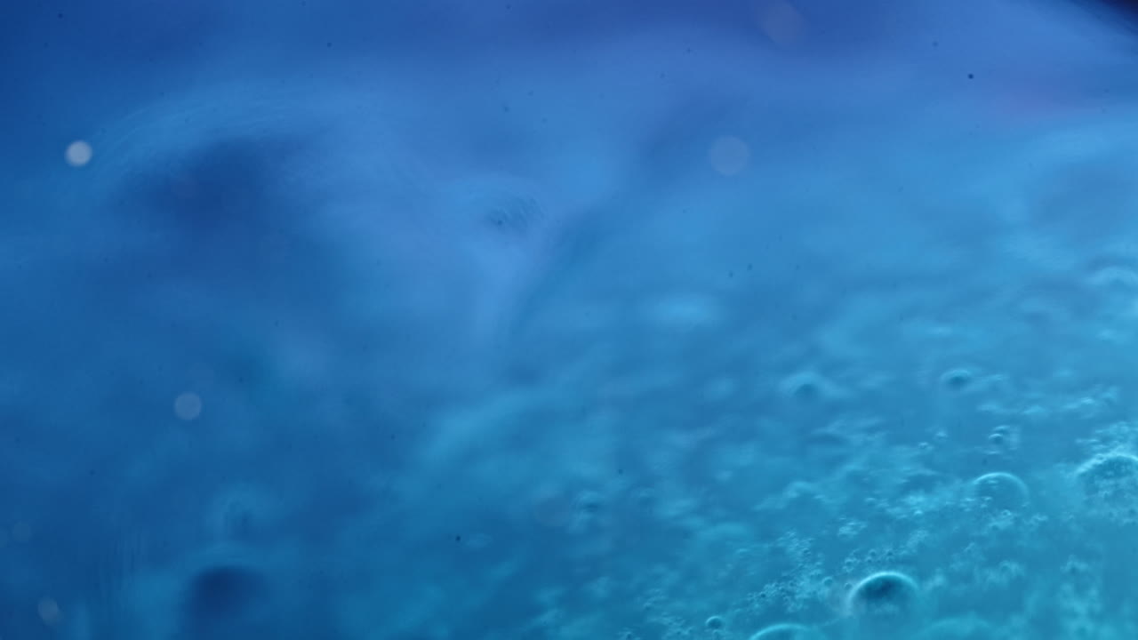 Colorful liquids mixing and blending in a vibrant macro shot with bubbles and soft lighting