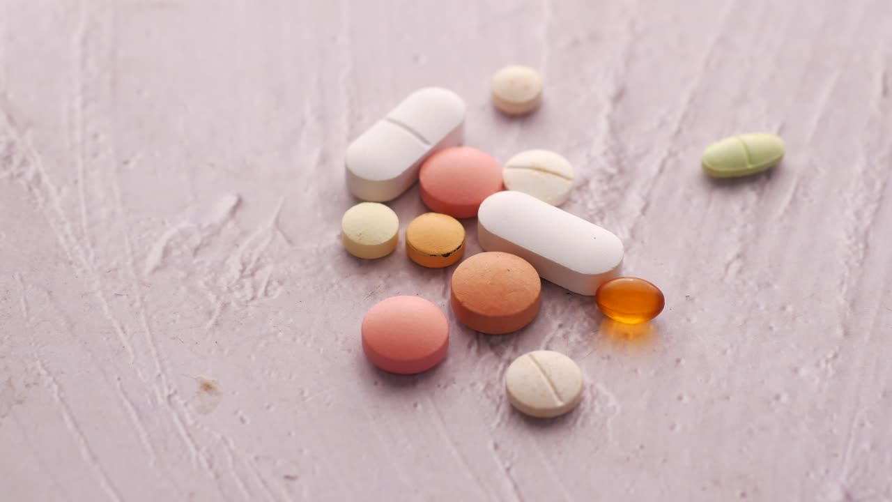 밝은 보라색 표면에 있는 다양한 알약과 태블릿