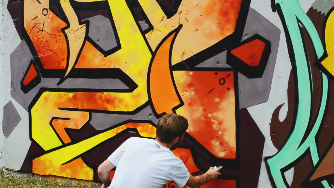 L'artista realizza graffiti su una recinzione. Disegno astratto