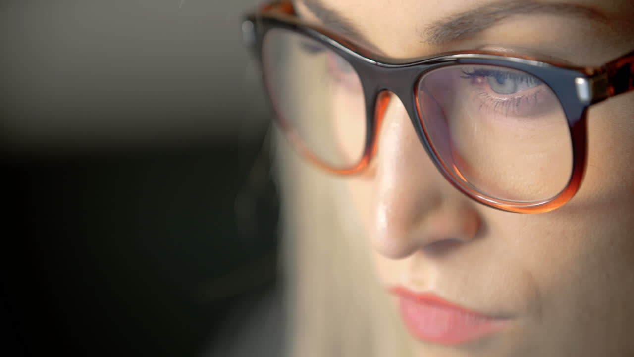 mujer de negocios que usa anteojos mientras usa una computadora portátil en la oficina 1