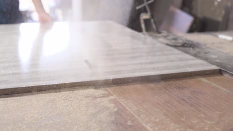 two people precisely cutting a wooden furniture board with a rotating blade