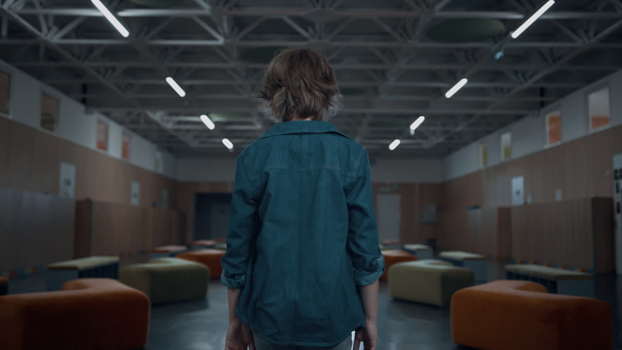 неизвестный школьник-подросток ходит по пустому коридору, студенты проходят мимо классов.