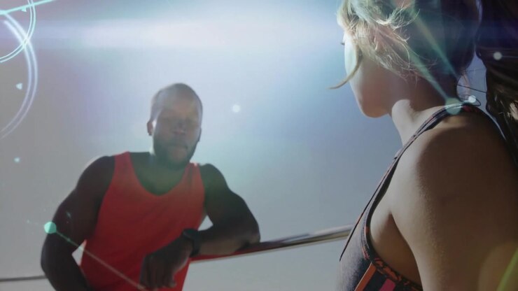 Woman swiping and activating digital graphics while partner checking tracker and planning workout